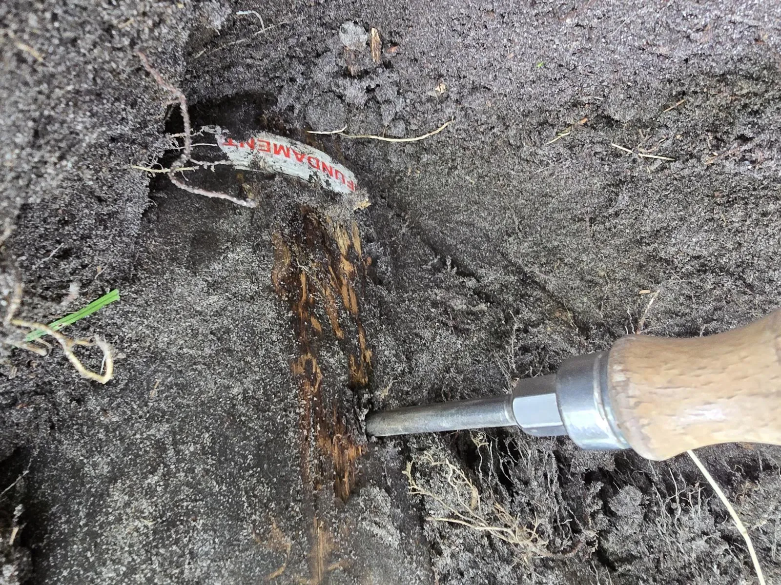 Prüfung eines Holzpfostens im Fundamentbereich